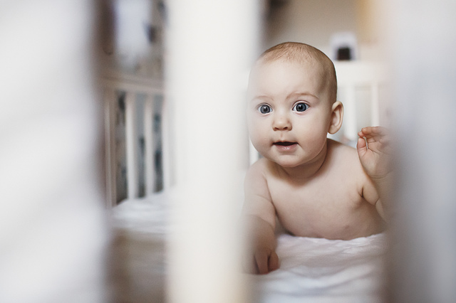 a family lifestyle photoshoot baby peaking through cot bars hollygoeslightly