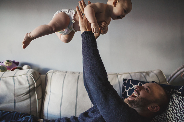 a family lifestyle photoshoot dad holding baby up in the air hollygoeslightly