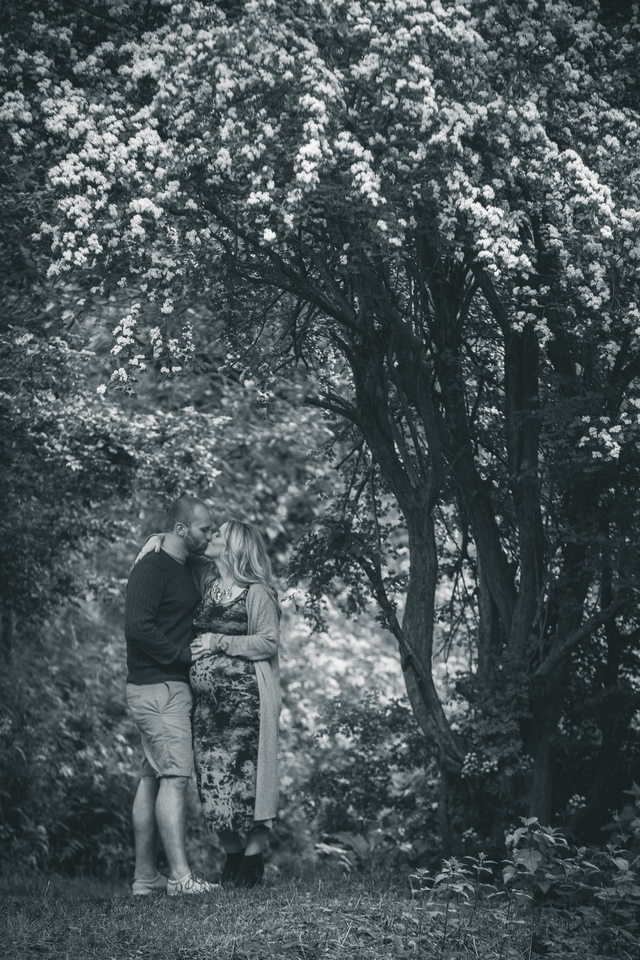 maternity photoshoot in the woods couple kissing hollygoeslightly