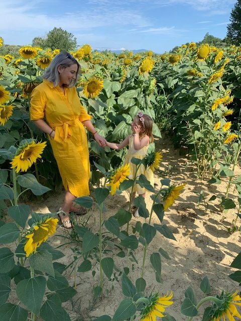 mum and daughter matching dresses boden sunflower fields holding hands tuscany